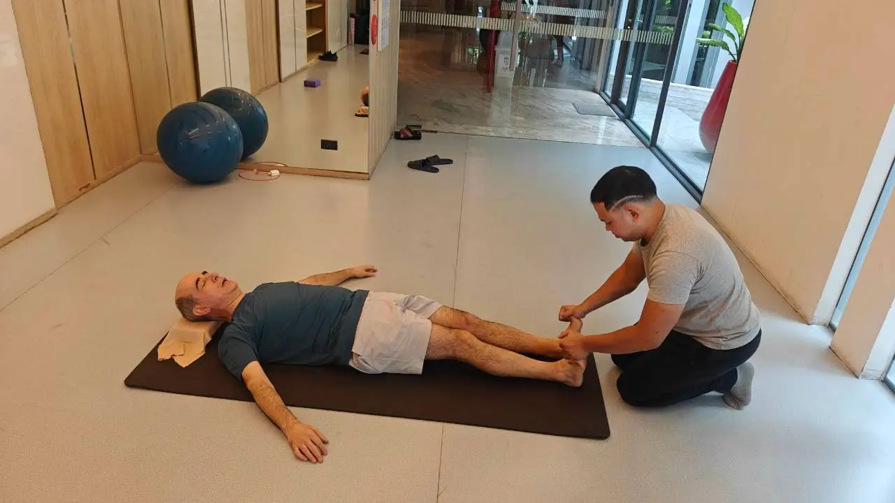Boss working on a client's ankle and leg during a post-injury session