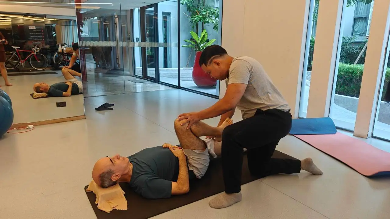 Boss moving a client's knee and hip through an assisted mobility exercise