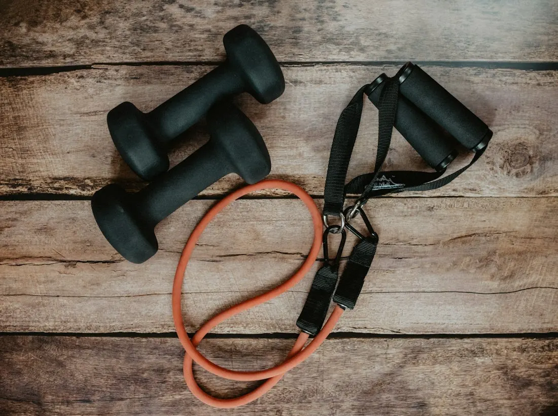 Dumbbells and resistance bands on a wooden floor